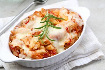 Delicious al forno pasta in baking dish on light table, closeup