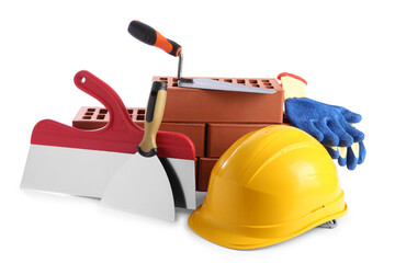 Fototapeta premium Yellow hard hat, red bricks, gloves, trowel and putty knives isolated on white. Building material and construction tools