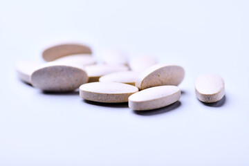 Ashwagandha (Withania somnifera) tablets. Concept for a healthy dietary supplementation. Bright paper background. Close up. Copy space.