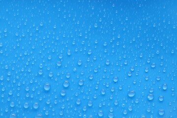 Water drops on blue background, top view