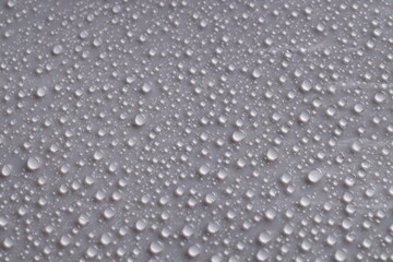 Water drops on gray background, top view