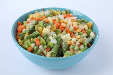 Mix of frozen vegetables in bowl isolated on white