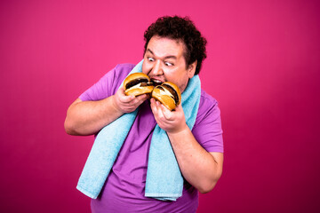 Sports and diet. Funny fat man eats a burger.