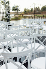 A wedding arch, decorated with flowers, stands on a podium, stands in the open air