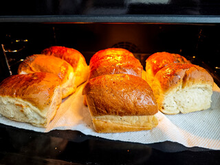 Close up plan of cooking homemade food, baking concept. Fresh hot soft fluffy ginger golden brown poppy seed buns pie bread dessert pastry in loaf pan. Bakery products, image with copy space.