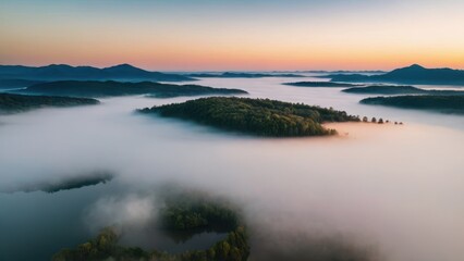 Fototapeta premium A breathtaking aerial view of islands covered in dense forest, surrounded by thick layers of fog floating over a serene lake. The mist blankets the valleys between the hills, creating a surreal, other