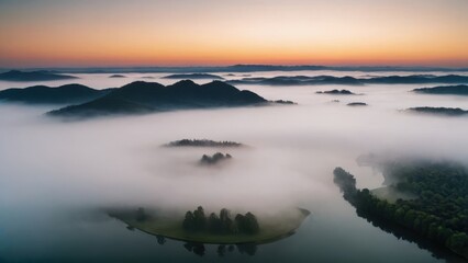 Obraz premium A breathtaking aerial view of islands covered in dense forest, surrounded by thick layers of fog floating over a serene lake. The mist blankets the valleys between the hills, creating a surreal, other