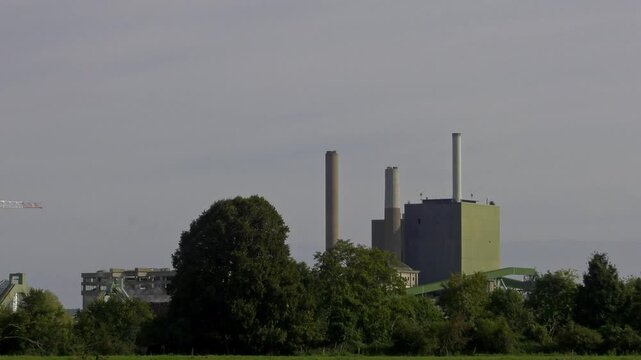 A view of a factory  cows grazing in a flooded field and then an overflowing river