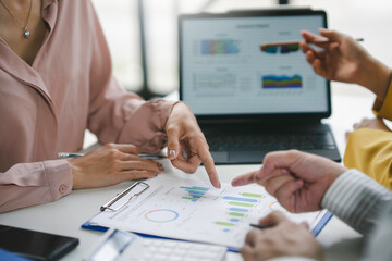 Business team working together analyzing financial charts and graphs discussing market growth at meeting