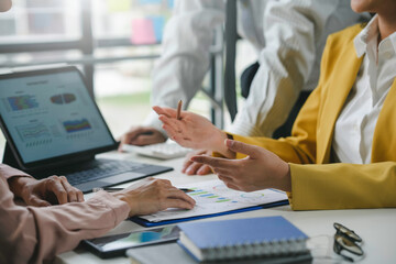Business team is discussing financial data on a report with charts and graphs, showing teamwork and collaboration in the workplace