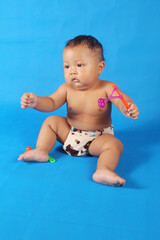 Adorable one year old Asian baby boy, playing lato lato style