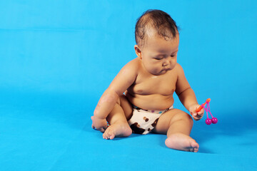 Adorable one year old Asian baby boy, playing lato lato style
