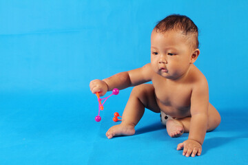 Adorable one year old Asian baby boy, playing lato lato style