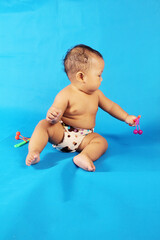 Adorable one year old Asian baby boy, playing lato lato style