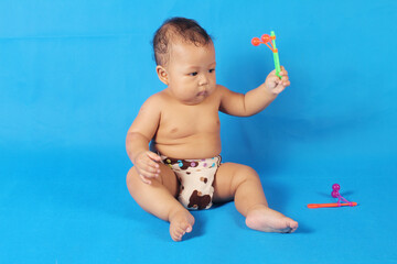 Adorable one year old Asian baby boy, playing lato lato style