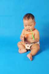 Adorable one year old Asian baby boy, playing lato lato style