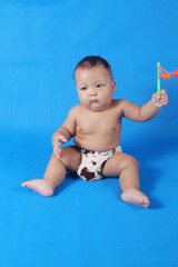 Adorable one year old Asian baby boy, playing lato lato style