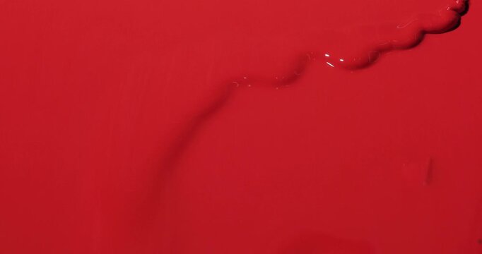 project video of red paint poured on red background and creating a monochromatic effect with dynamic movement for energy and emotion