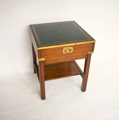 Mahogany side table in military style with green leather table top and brass handles.
