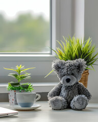 A cozy desk scene featuring a teddy bear, a plant, and a cup, creating a warm atmosphere.