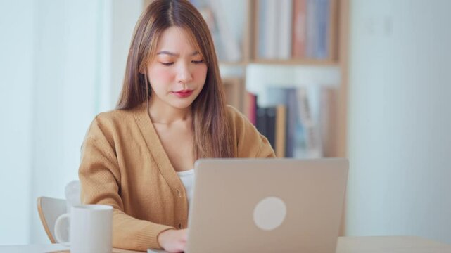 Sad Asian woman read bad news on laptop look desperate at home, feels stressed due unsaved document, device malware, file error.