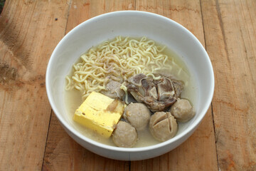 a bowl of meatballs and noodles and tofu and ribs
