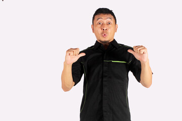 Side view of mature Asian man smiling confidently and giving thumbs up to his own body
