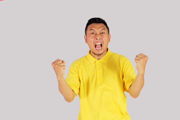 Naklejka premium mature asian man showing happy expression with clenched fist 