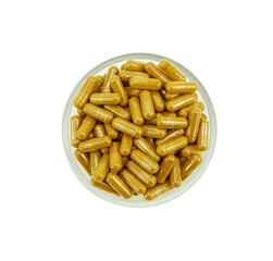 Top view of a group of turmeric herbal capsules in a small glass bowl on a white background.