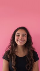 Fototapeta premium A confident Hispanic woman smiles brightly against a solid pink background