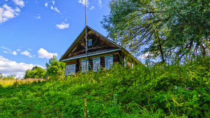 Old wooden house in the village on a sunny summer day