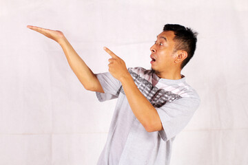 Asian adult man smiling happily after getting a new idea with his pose opening his arms and showing...
