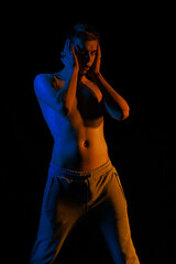 Young man posing in the dark with red and blue light in the studio