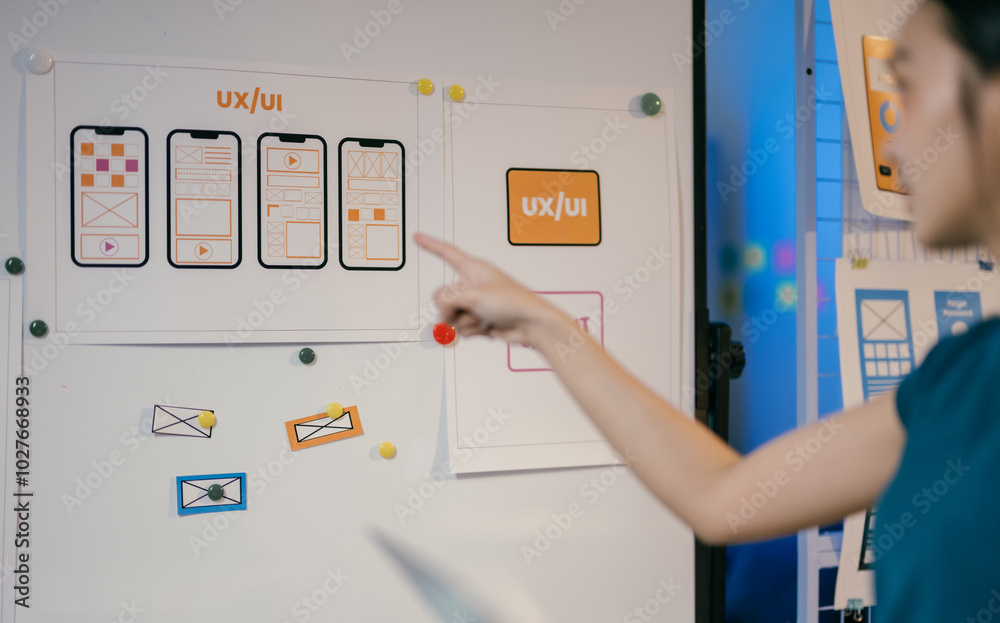 Poster Ux ui designer pointing at a whiteboard with website wireframes and explaining the design process during a presentation
