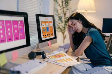 Young woman is holding her head, dealing with a painful headache while working on a challenging...
