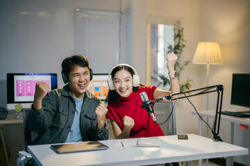Obraz premium Two podcasters celebrating success in their recording studio, surrounded by technology, teamwork, and a cheerful modern lifestyle