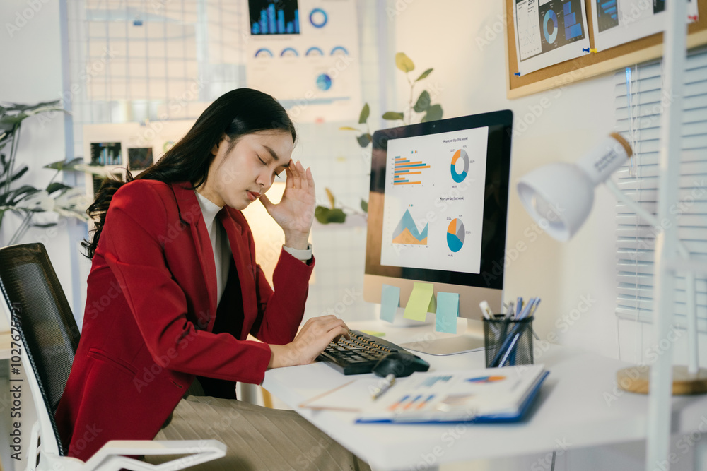 Poster young businesswoman is having a headache and feeling tired from working on a computer all day. she i