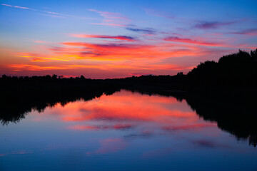 Sunset clouds above the calm lake