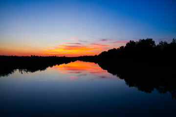 Sunset clouds above the calm lake