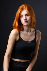 Fototapeta premium Cute red-haired girl, studio portrait on a black background.