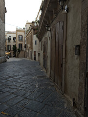 Narrow street in the old town center. Facade of old buildings. Puglia, Italy.