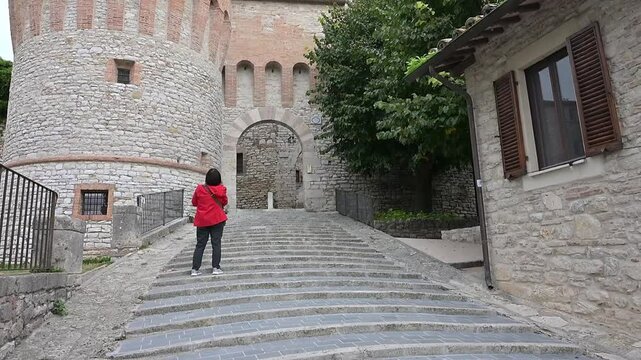 Turista fotografa l'ingresso al borgo medievale di Corciano (PG)