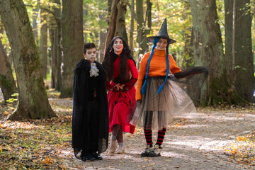 halloween in autumn forest, orange sweater, witch in striped stockings, teenager, boy dracula, red,  funny witch, halloween, day of the dead holiday, dressed up witch