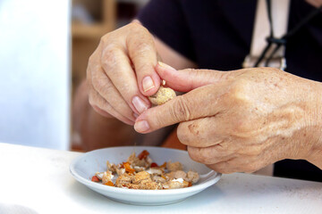 woman's hands shelling peanuts