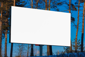 Advertising billboard along the road in the city on a winter day. Background for design. 