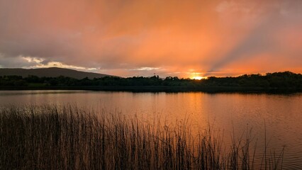Beautiful orange sunset lakeside landscape scenery at Ross lake, Roscahill, Galway, Ireland, nature background