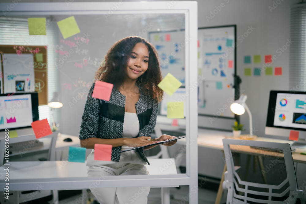 Poster young manager is holding a clipboard and thinking about her next move while working in the office. s