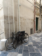 Bicycle in front of a house. Narrow street in the old town center. Polignano a Mare, Puglia, Italy.