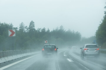 Cars racing down a wet highway in heavy rain