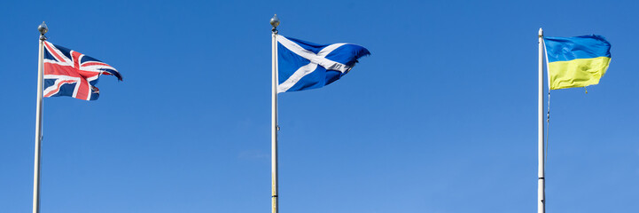 Ukraine, British and Scottish flags fluttering in the wind suspended high the in sky